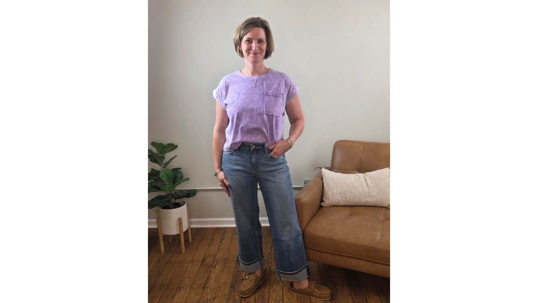 Woman wearing slim wide leg jeans and lavender snow washed crop tee, both from Cosmos and Clover Boutique