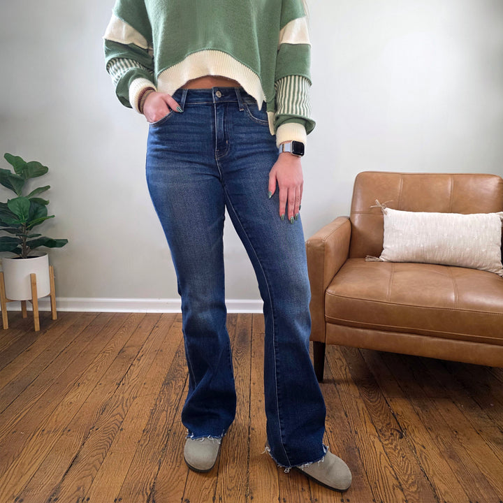 Someone stands on a wooden floor near a tan armchair and potted plant, wearing Lovervet&