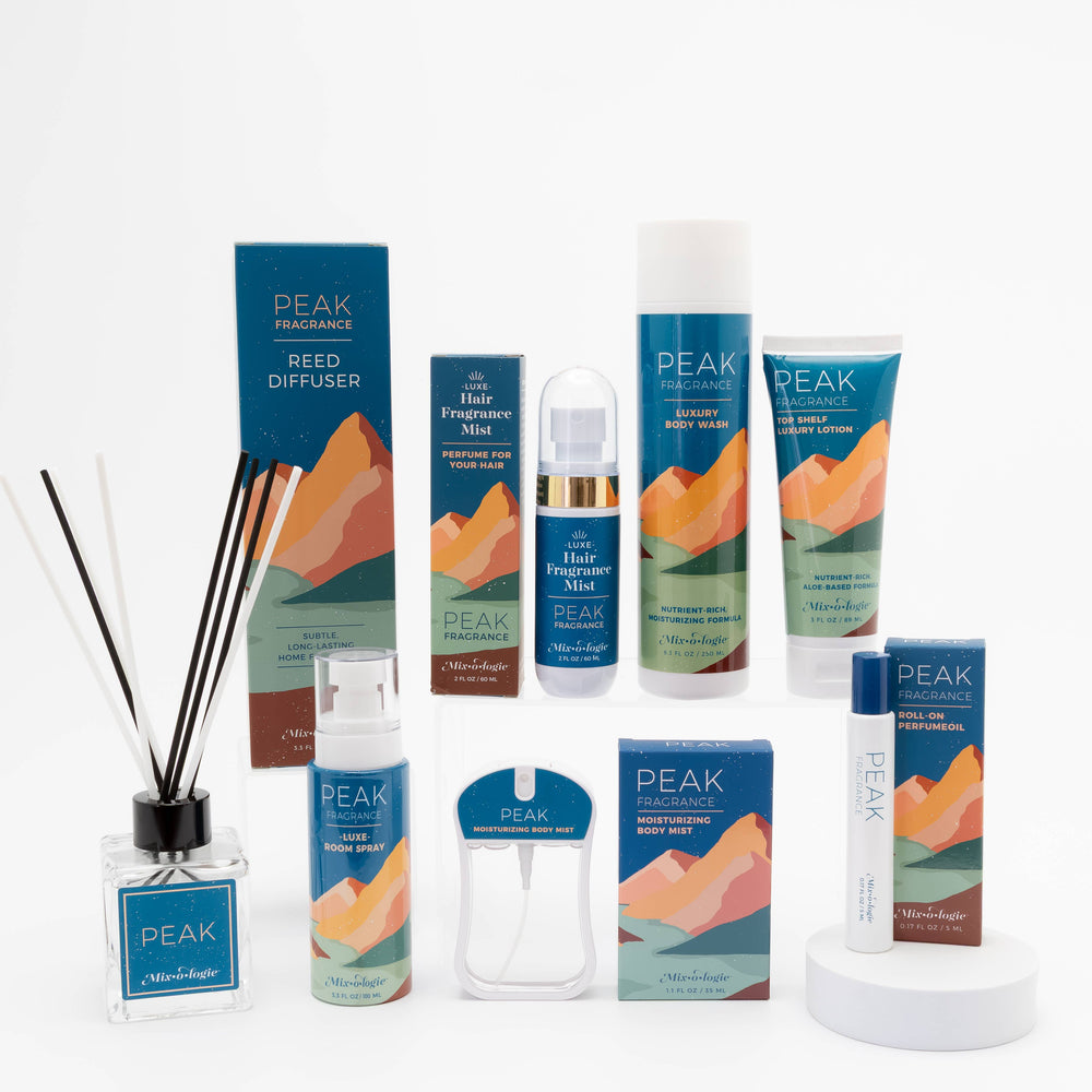 A Mixologie Peak Reed Diffuser is displayed on a white surface with clean white background, showcased in blue mountain-themed packaging.