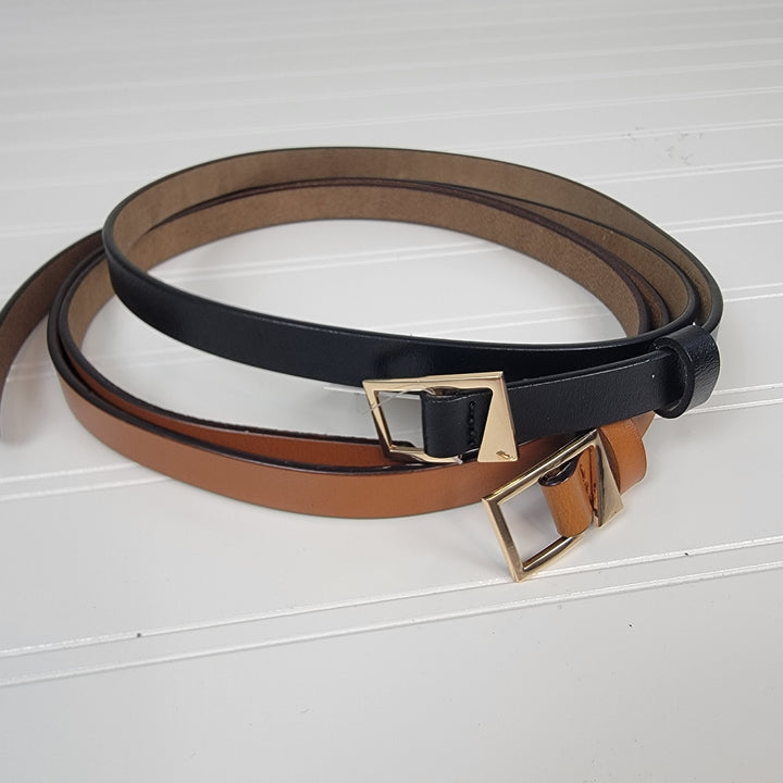 The Leto Collection Asymmetrical Buckle Skinny Belts—one black and one brown—are displayed overlapping on a textured white surface.