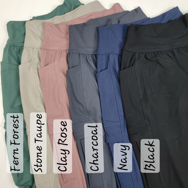 Six pairs of leggings—Fern Forest, Stone Taupe, Clay Rose, Charcoal, Navy, and Black—are displayed side by side. Pair them effortlessly with your favorite Carolina Joggers from Rae Mode for a comfortable and stylish look.