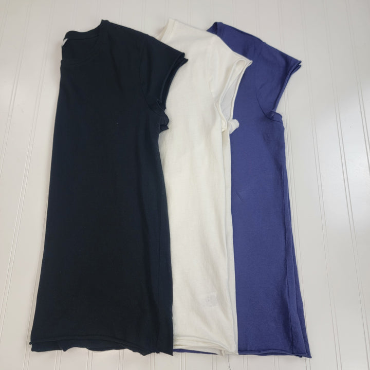 Three sleeveless Meriah Tee shirts by HYFVE, Inc.—in black, white, and blue—are laid flat side by side on a white wooden surface. Each 100% cotton tee offers comfort and breathability for daily wear.