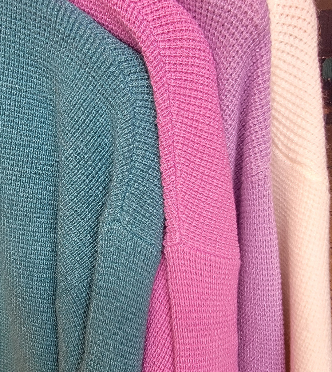 Four Nola Cardigans by Zenana in teal, pink, purple, and light beige hang together, featuring cozy drop shoulders in extended sizes and showcasing their textured fabric and pastel shades.