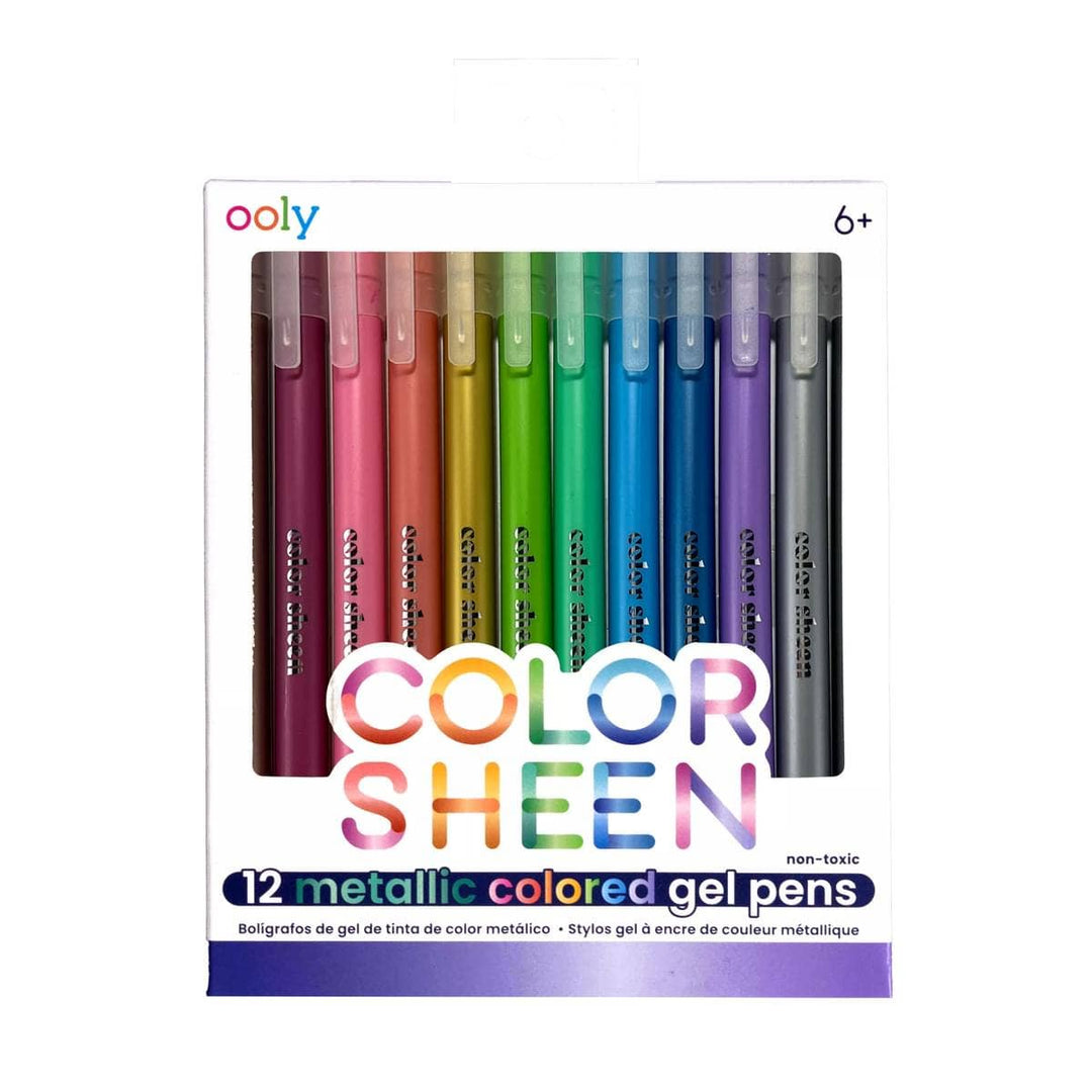 A set of 12 OOLY Color Sheen Metallic Gel Pens, packaged in white with colorful text, displays pens in a row with vibrant caps. The packaging indicates it’s suitable for ages 6 and up.