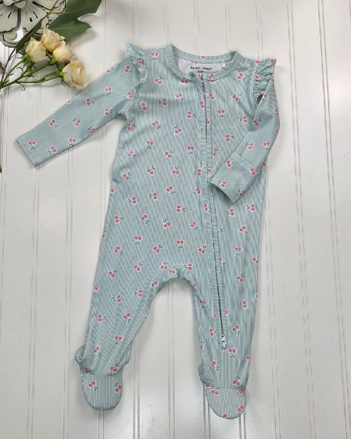 The Tiny Cherry Stripe - 2 Way Ruffle Sleeve Zipper Footie by Angel Dear, in light green and white stripes with pink floral prints and ruffled shoulders, is displayed on a white wooden surface with cream flowers in the top left corner.