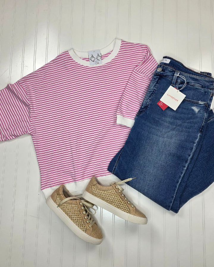 Sylvia Striped Contrast Trim Rib Banded Top by ZENANA in candy pink, blue Levi’s jeans with tags, and beige lace-up sneakers—this versatile trio is arranged flat on a white surface.