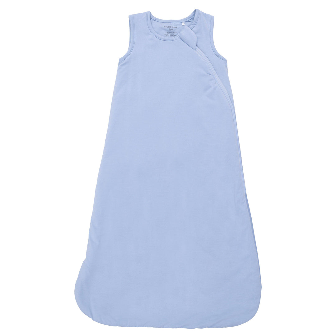 The Angel Dear Solid Blue Fog Sleep Bag is a sleeveless, light blue bamboo sack with a rounded bottom, subtle texture, and a fabric knot near the neckline, displayed against a white background.