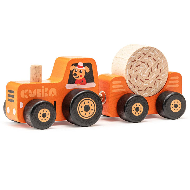 The Toysmith Cubika Wooden Toy Tractor, made from organic wood, features a detachable trailer with magnetic fasteners carrying a cylindrical log. Both the tractor and trailer have four black wheels and display a playful dog illustration.
