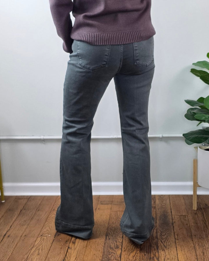 Back view of Jessica High Rise, Olive Flares from Risen with Tummy Control denim flares in a high-rise cut, worn with a purple sweater.