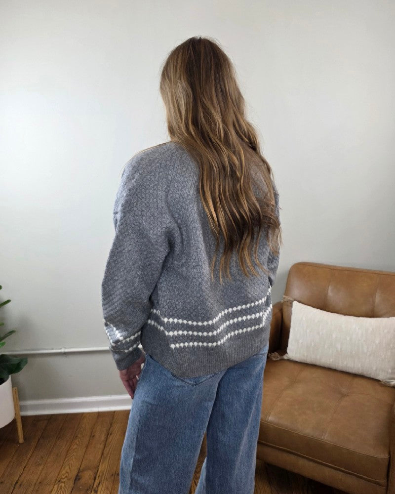 A person seen from behind wears a grey Sierra Honeycomb Textured Cardigan with two white horizontal stripes near the hem, paired with blue jeans.