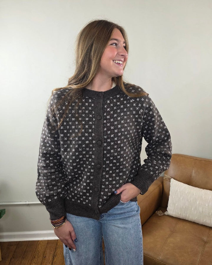 A woman wears a chocolate brown, crew-neck Staccato Sylvia Detailed Button Down Sweater with a white repeating geometric pattern.