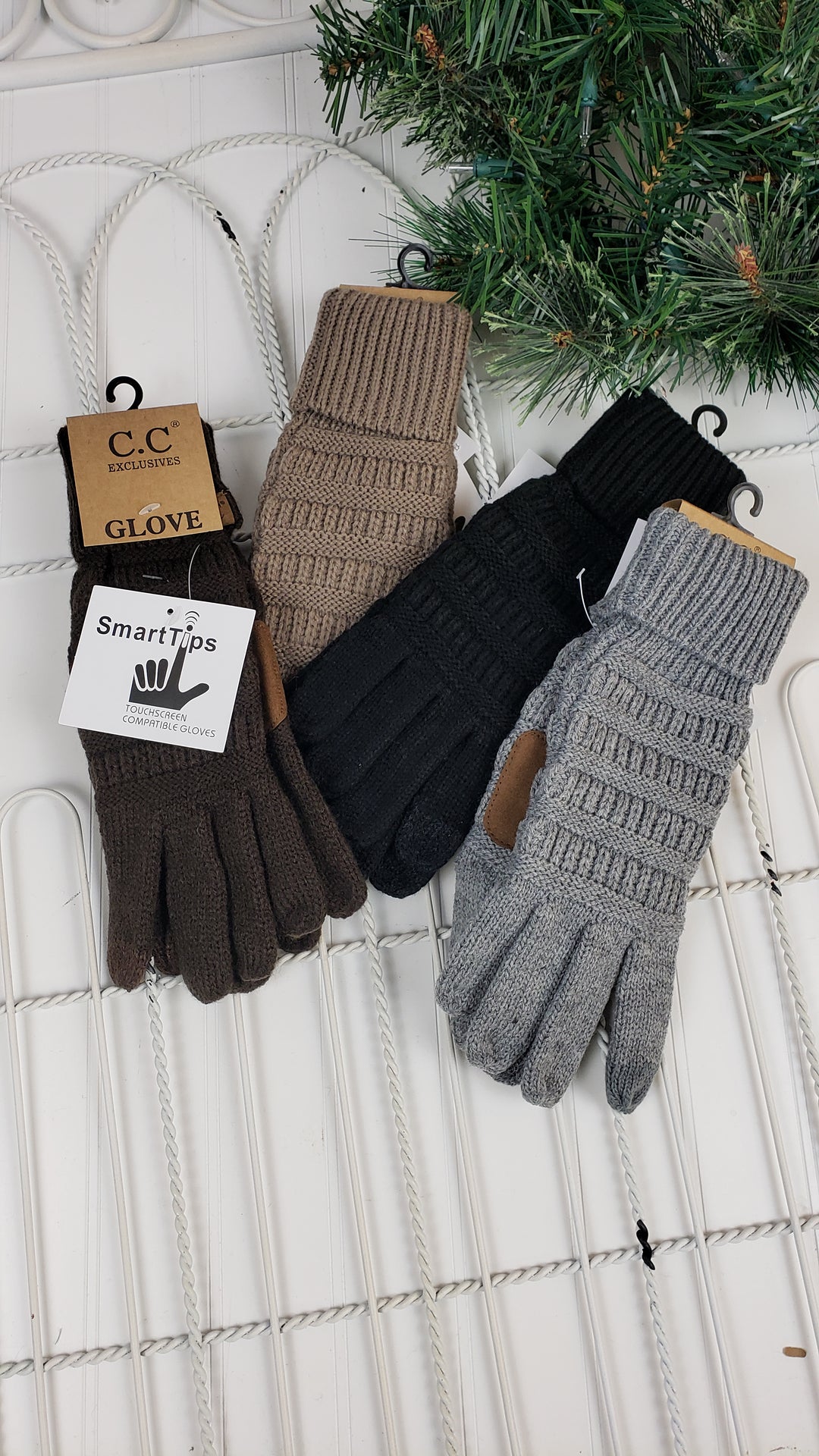 Three pairs of CC Beanie Glove ($13 each) by CC Beanie in brown, black, and gray are displayed side by side on a white background with a green branch in the corner. Two pairs have tags attached.