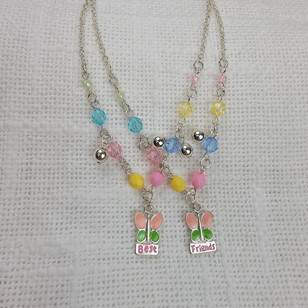 The Girls Charm Jewelry: Best Friends Sets by 2HOPE Accessories, Inc features two matching necklaces with pastel beads and butterfly charms—one says “Best,” the other “Friends”—making a cute friendship gift alternative to bracelets.